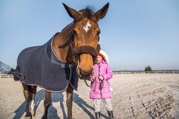 Horse and girl baby. Make friends with an animal