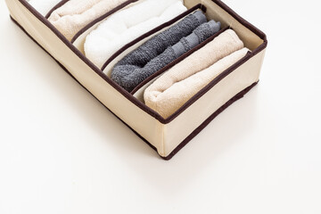 Clothing organizer with towels on white background. Space for text