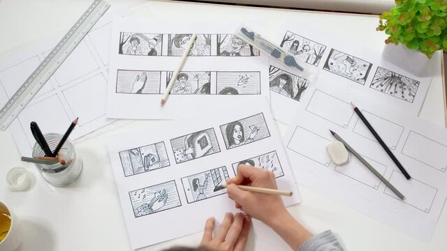 Artist animator draws cartoon storyboard sketches. Comics concept. 4K.