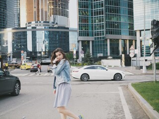 Fototapeta premium young woman extinguishes in the city near the skyboxes and in the subway