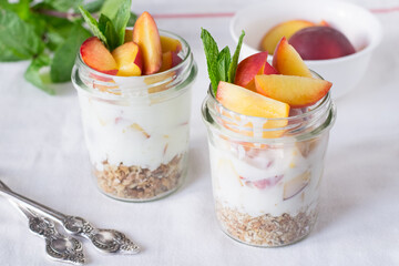 Yogurt with muesli and peaches in glasses
