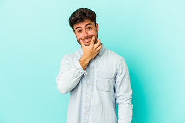 Fototapeta premium Young caucasian man isolated on blue background doubting between two options.
