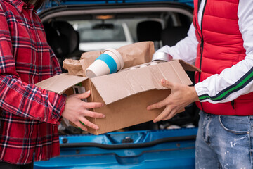 cropped view of young man and woman holding carton box with reusable cup