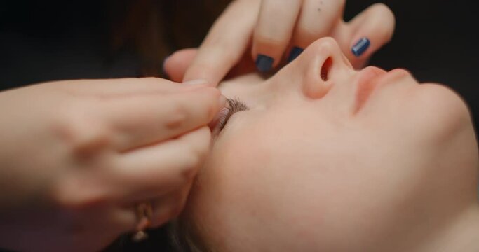 Lashmaker does the eyelash lamination procedure for the client in the beauty salon, cosmetic services, beauty care procedures, 4k 60p Prores HQ