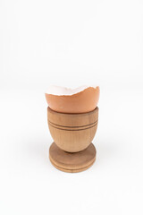 Vertical shot of broken egg shell in old wooden egg stand. Minimalism. Conceptual art for food or animal products. Sustainability issue. Simple breakfast.