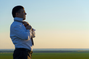 businessman poses in a green field, freelance and business concept, green grass and blue sky as background