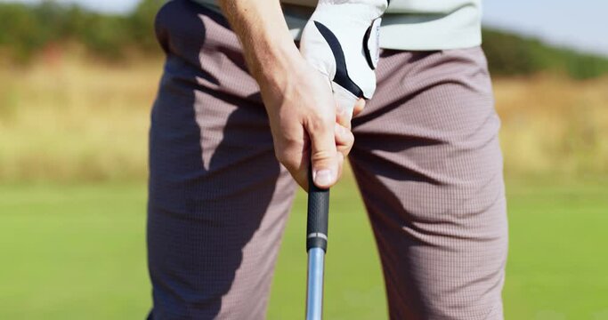 Professional golf player. Unrecognizable man wearing golf glove taking golf club and standing in hitting position