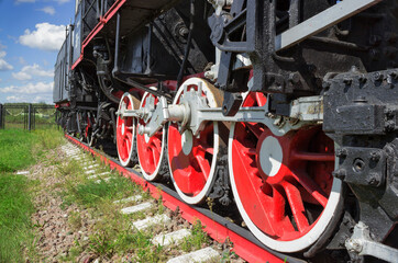 Fototapeta na wymiar Wheels and coupling devices of a big old steam locomotive