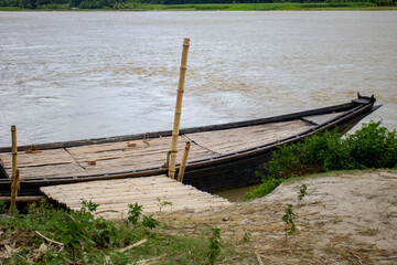 A large wooden boat tied to the river bank. This is a big river crossing Boat. A beautiful river of Bangladesh.
