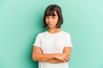 Young mixed race woman isolated on blue background suspicious, uncertain, examining you.