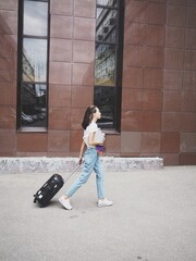 
a young woman leaves with a suitcase on wheels. Baggage, airport, vacation