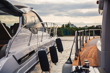 Moored yachts, sport boats close-up. Scenic landscape background. Holiday rest during summer...