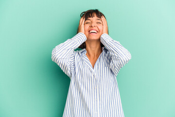 Young mixed race woman isolated on blue background shrugs shoulders and open eyes confused.