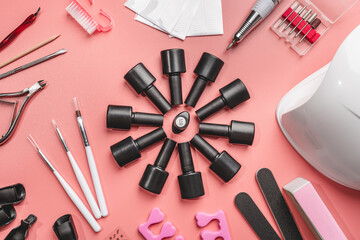 manicure and pedicure tools and other nail essentials on pink background top view. nail work flat lay concept