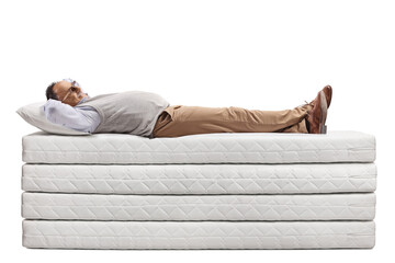 Mature man lying on a pile of mattresses