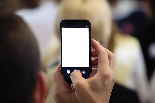 A man takes a photo or video on his phone. White phone screen with the ability to insert text or images.
