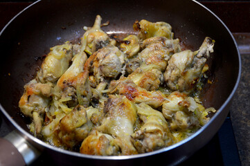 home cooking, fried chicken wings with onions in a pan