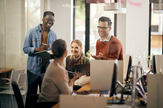 Young happy start-up team talking during business meeting in the office. - Powered by Adobe