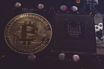 Bitcoin coin and processor on an electronic chip board. Soft focus