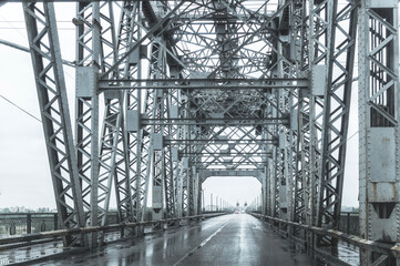 Steel lift bridge and rain-wet asphalt road