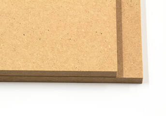 Two boards of raw MDF on a white background are ready for use in the construction or furniture industry.