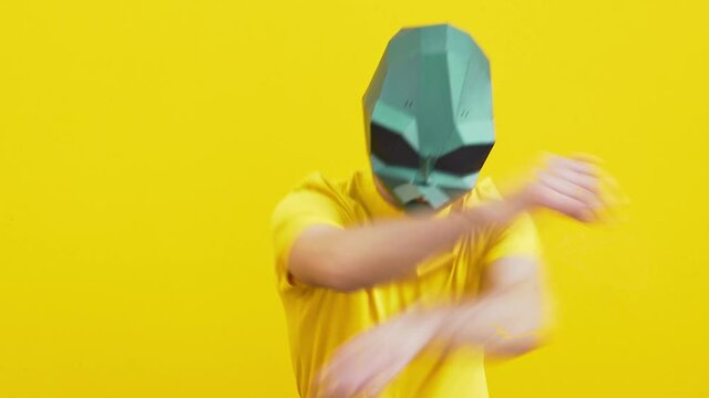 Cool man wearing 3d origami mask with stylish colored clothes