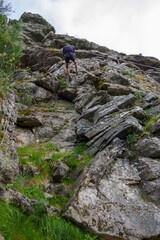 Rock climbing young man with rope and harness. Extreme ascent. Top wall