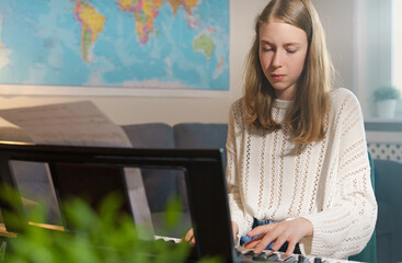 Teenage girl playing electronic musical instrument at home.
