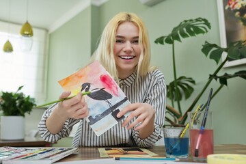 Teenage girl recording video drawing lesson, watching and showing painting techniques to camera