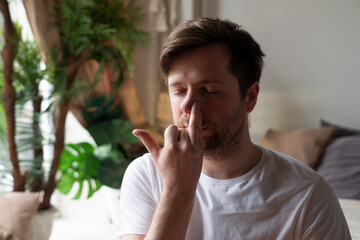 Caucasian mature man practicing yoga sitting, making Alternate Nostril Breathing
