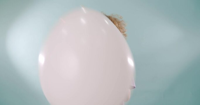 Playing with the big balloon while making faces