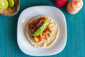 Rich shrimp taco with avocado with blue background