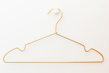 a wire hanger hangs on a hook against a white wall