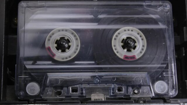 static close-up footage of vintage audio cassette playing in a tape recorder 