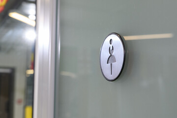 round sign for women's toilet on the door
