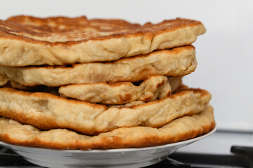 a plate of thick white flour tortillas on a plate.