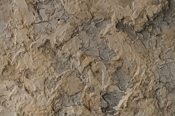A concrete wall covered with beige paint