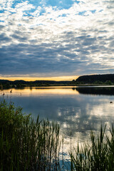 sunset at coast of the lake. Nature landscape.  reflection, blue sky and yellow sunlight. landscape during sunset.