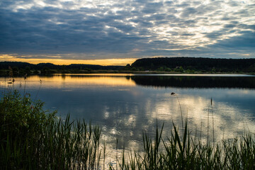 sunset at coast of the lake. Nature landscape.  reflection, blue sky and yellow sunlight. landscape during sunset.