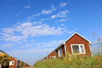 Fototapeta na wymiar The wooden house in the background of blue sky