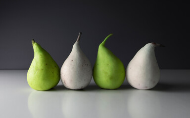 Close-up of four pears, dark background
