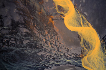 Aerial view of a colourful river estuary along the coastline facing the ocean, Rangárbing eystra, Southern, Iceland.