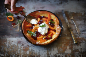 Dutch baby pancake with fruit and ice cream. Summer dessert.