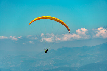 Paraglider sportsman fly over mountains