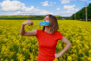 Young pretty woman in a colored dress on Lightning cheerful yellow background blooming rapeseed...