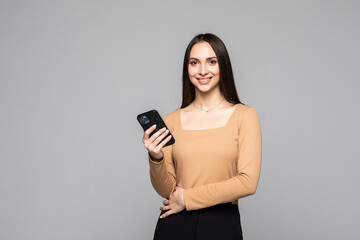 Naklejka premium Content woman use phone, isolated over grey background