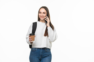 Happy young woman university student with backpack and books talking on cell phone isolated on white background