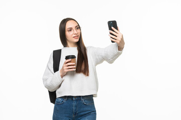 Naklejka premium Happy female student with backpack making selfie photo on a white background