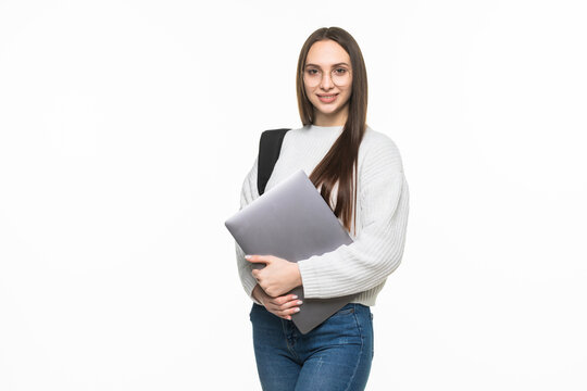Happy cute student woman with backpack standing and holding laptop isolated on a white background