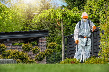 Gardener Working in Protection Suite Spraying Plants